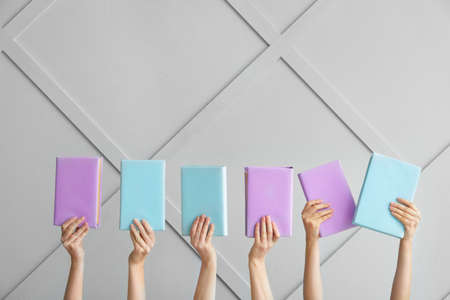 Female hands with books on light backgroundの写真素材