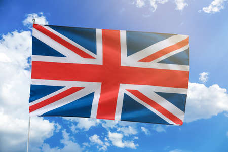 The national flag of the United Kingdom against blue sky