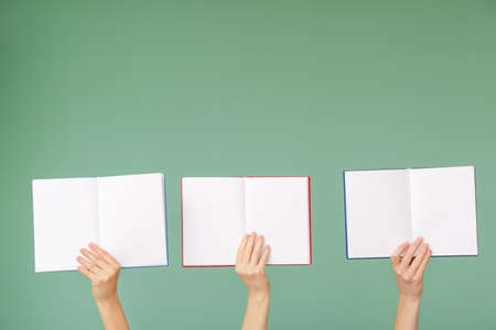 Female hands with books on color backgroundの写真素材