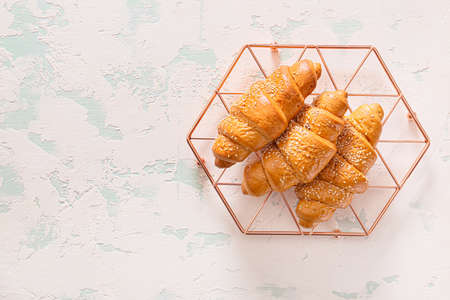 Grid with tasty croissants on white background