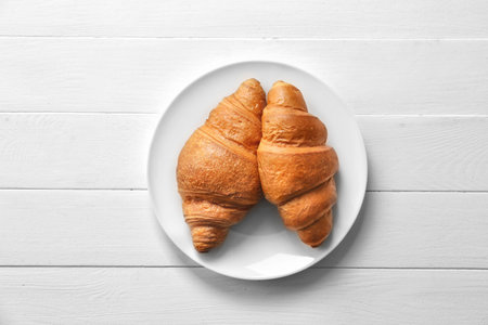 Plate with tasty croissants on tableの写真素材