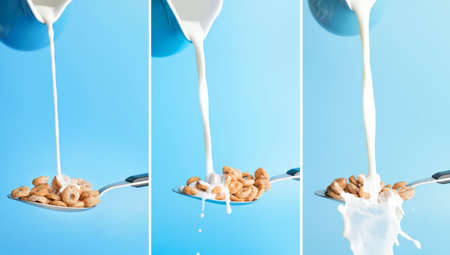 Pouring of milk from jug into spoon with cereal rings on color background