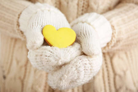 Woman in warm mittens and with tasty cookie, closeup