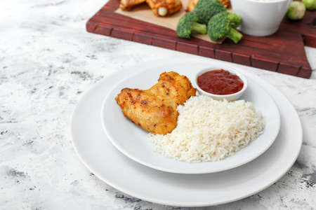 Tasty rice and chicken with sauce on white tableの写真素材