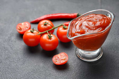 Gravy-boat with tasty barbecue sauce on tableの写真素材