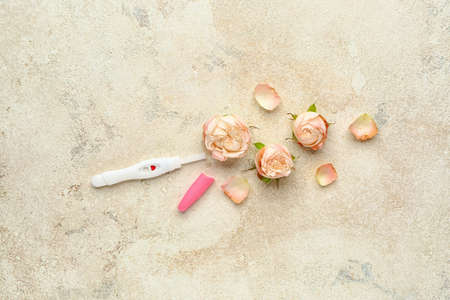 Pregnancy test and flowers on light backgroundの写真素材