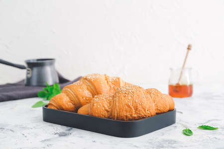 Plate with tasty croissants on white tableの写真素材