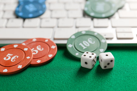 Chips for gambling games, dices with computer keyboard on color backgroundの写真素材
