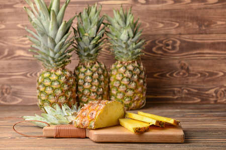 Fresh ripe pineapples on wooden background