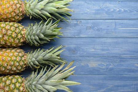 Fresh ripe pineapples on wooden backgroundの写真素材