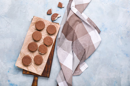 Board with tasty chocolate cookies on color background