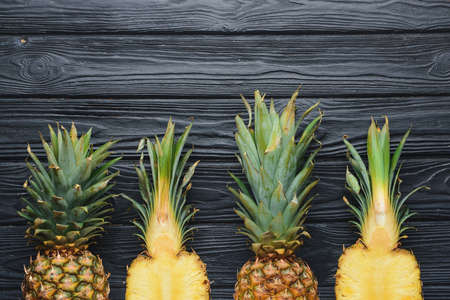 Fresh ripe pineapples on wooden background