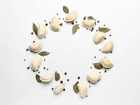 Frame made of raw dumplings with spices on white backgroundの写真素材