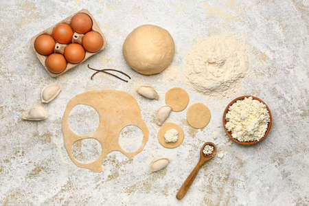 Raw dough and dumplings with ingredients on white background