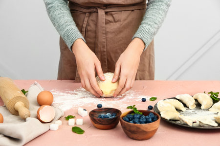 Woman cooking tasty dumplings, closeup