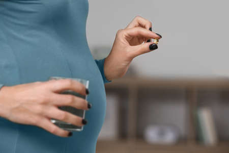 Pregnant woman with fish oil at home