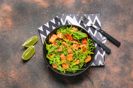 Plate with tasty salmon salad on dark backgroundの写真素材