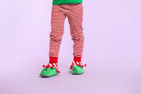 Little girl in costume of elf on color backgroundの写真素材