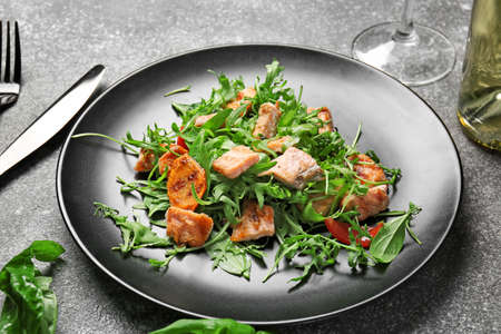 Plate with tasty salmon salad on dark backgroundの写真素材