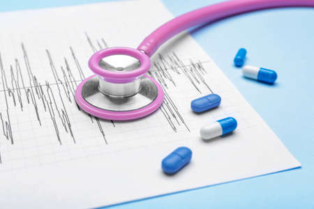 Stethoscope, pills and cardiogram on color backgroundの写真素材