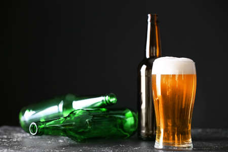 Glass of beer and bottles on table. Concept of alcoholismの写真素材