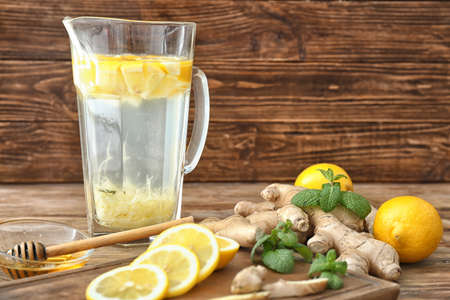 Jug of tasty ginger lemonade on table