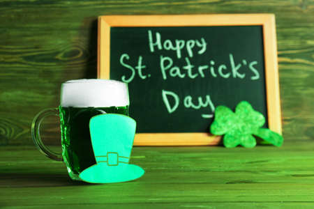 Mug of green beer for St. Patrick's Day on wooden table