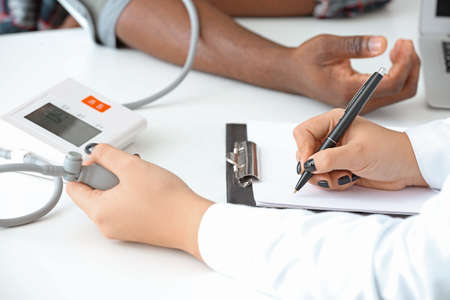 Female cardiologist examining male patient in clinic