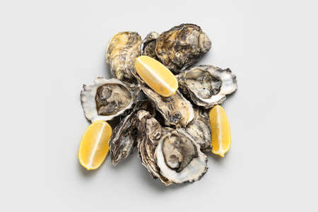 Tasty oysters with lemon on white backgroundの写真素材
