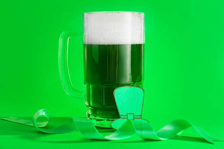 Mug of green beer for St. Patrick's Day on color backgroundの写真素材