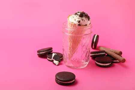 Jar with tasty ice-cream and chocolate cookies on color backgroundの写真素材
