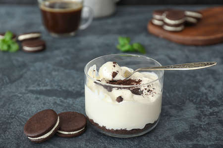 Glass with tasty ice-cream and chocolate cookies on dark background