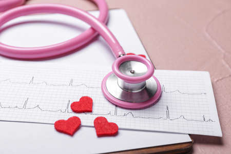 Stethoscope, hearts, clipboard and cardiogram on color backgroundの写真素材