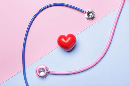 Stethoscopes and heart on color background. Cardiology conceptの写真素材