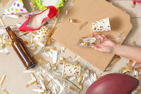 Unconscious woman lying on floor with terrible mess after New Year party