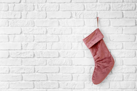 Christmas sock hanging om white brick wallの写真素材