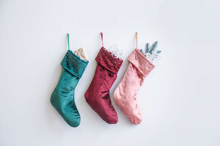 Christmas socks with gifts hanging on white wall