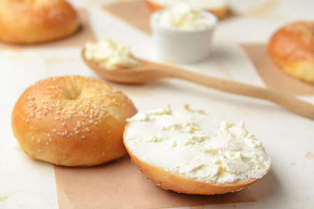 Fresh bun with tasty cream cheese on white backgroundの写真素材