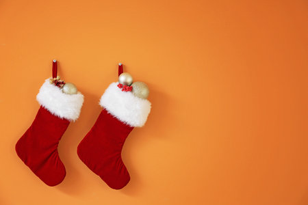 Christmas socks with gifts hanging on color wall