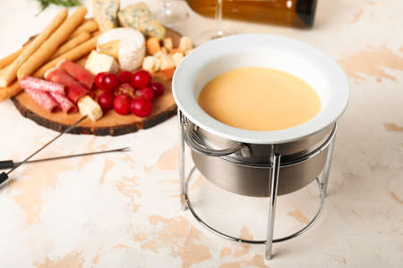 Cheese fondue with snacks on white backgroundの写真素材