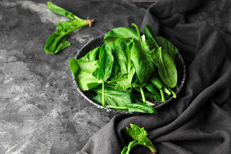 Plate with fresh green spinach on tableの写真素材