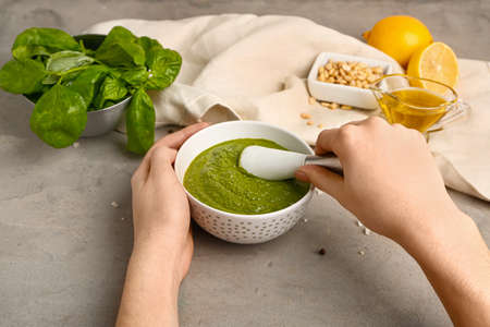 Woman preparing healthy pesto sauce