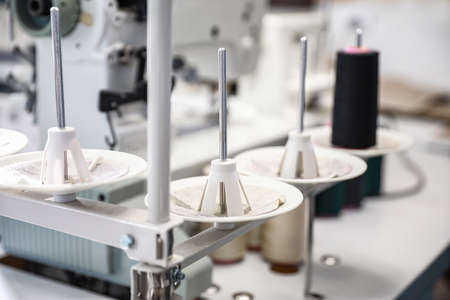 Modern sewing equipment in tailor workshop, closeup