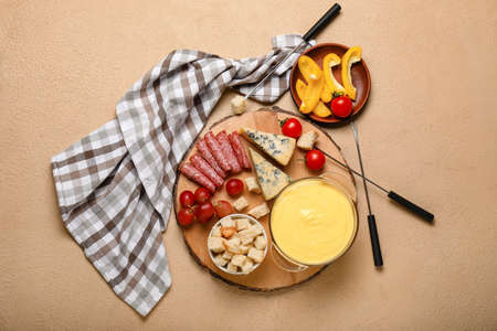 Cheese fondue with snacks on color backgroundの写真素材
