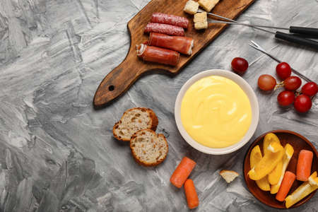 Cheese fondue with snacks on gray backgroundの写真素材