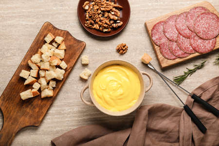 Cheese fondue with snacks on tableの写真素材