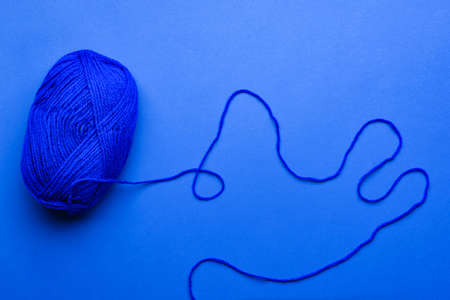Blue knitting yarn on color backgroundの写真素材