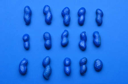 Blue painted peanuts on color backgroundの写真素材