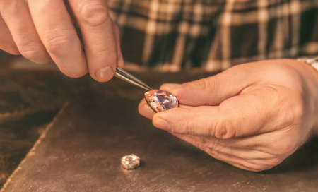 Jeweler examining gemstone in workshop, closeup