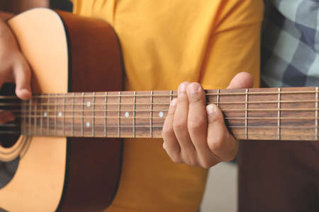 Little boy playing guitar at music school, closeup